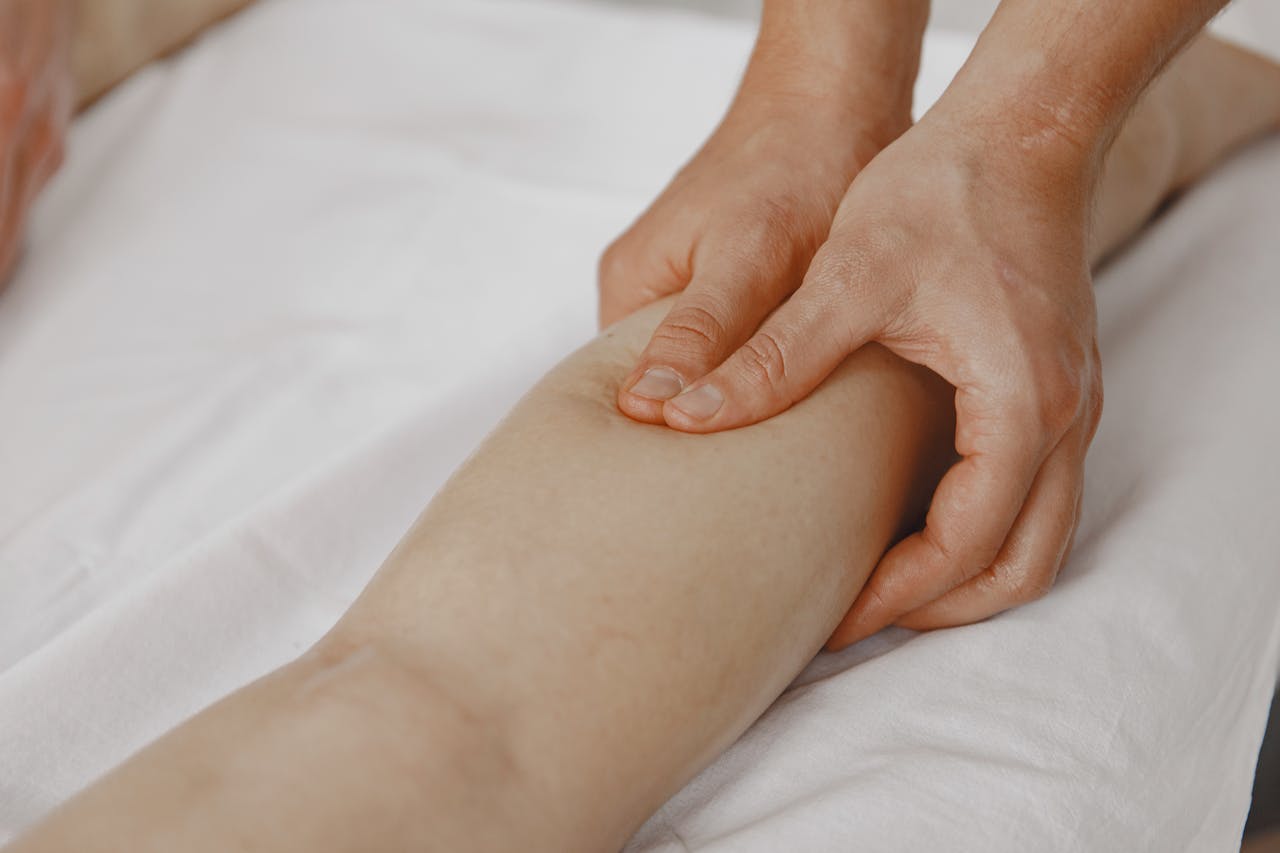about-img Close-up image of a massage therapist applying pressure on a clients leg for muscle relaxation.